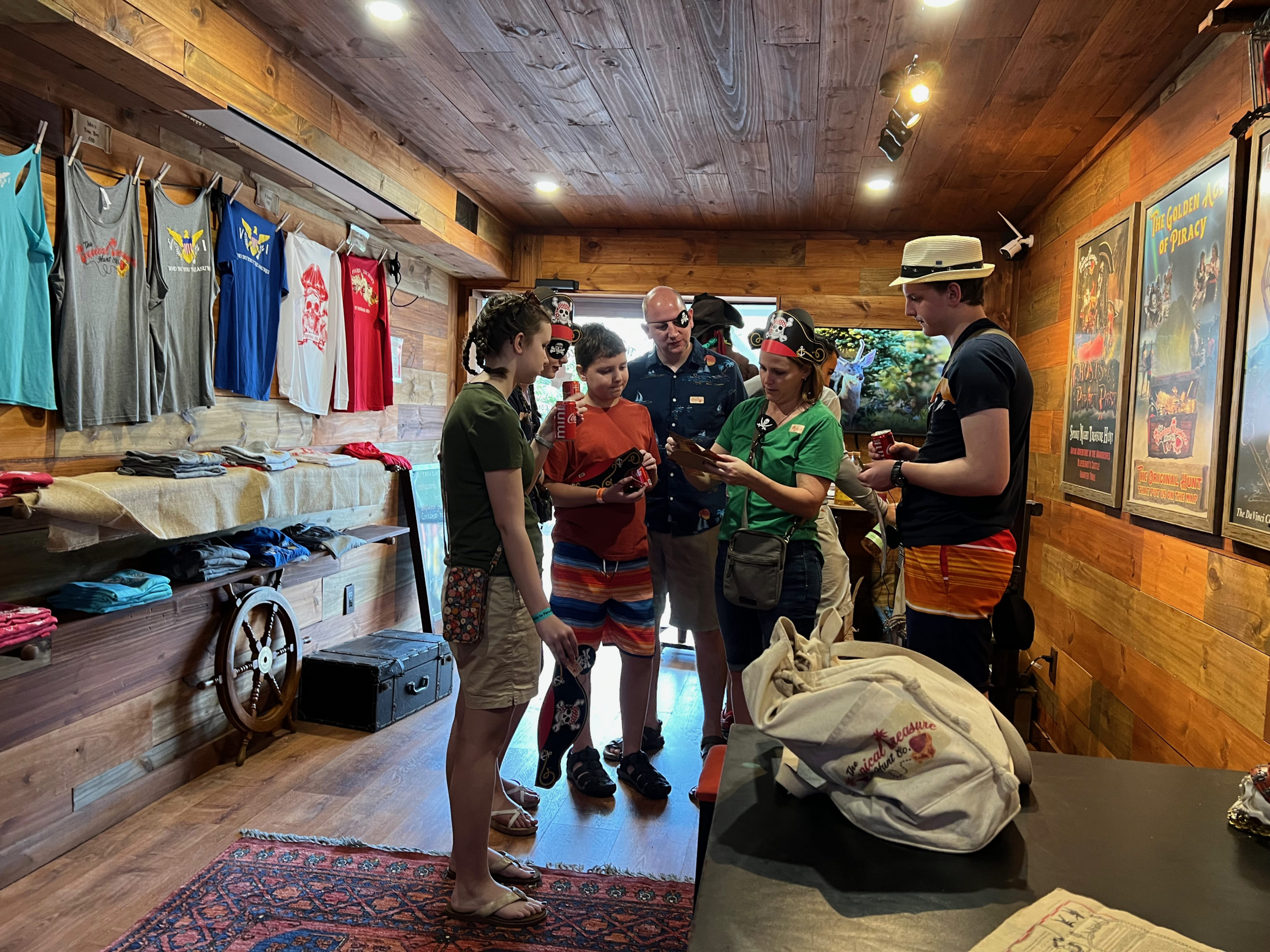 A group of people in pirate swag gather around a clue in the Captains Quarters Store Front